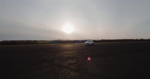 White Sports Car Drifting on Pavement at Sunset