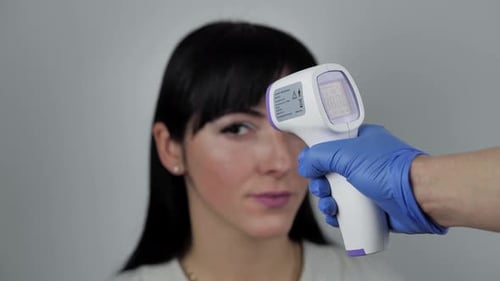 Close Up Video of Contactless Thermometer Used To Check Temperature Brunette Young Female