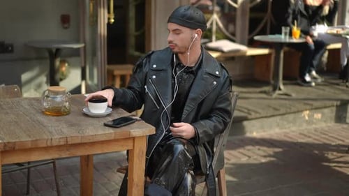 Stylish Young Adult Drinking Tea in City Cafe