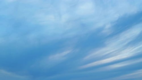Wispy Clouds Flowing in Blue Sky