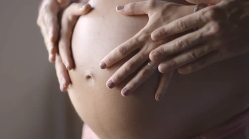 Maman et papa mettent la main sur le ventre d'une femme enceinte