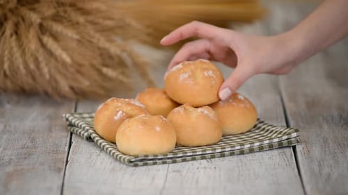 Pile of Fresh Baked Rolls on Wooden Table