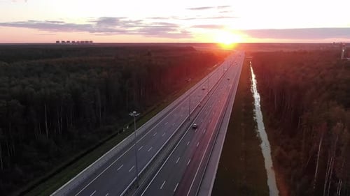 Fahrt über eine breite Autobahn mit fahrenden Autos und Kanal