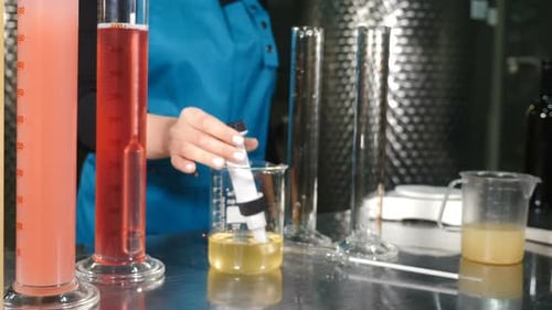 Un scientifique verse du liquide vinicole dans un tube à essai pour contrôler la qualité