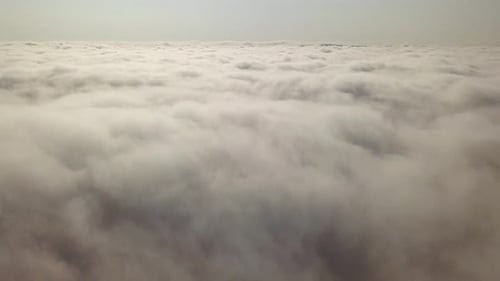 Aerial footage of flight over white puffy clouds