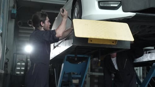 male mechanic checking and repair the engine at car garage service, automobile technician man