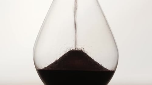 Elegant Hourglass with Flowing Dark Grains of Sand