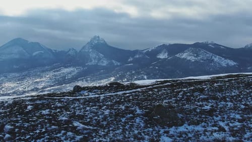 Winter Morning Jogging Along the Trail Against the Backdrop of a Snow Covered Mountain Range