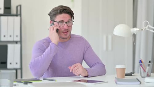 Man Answers Phone Call at Desk