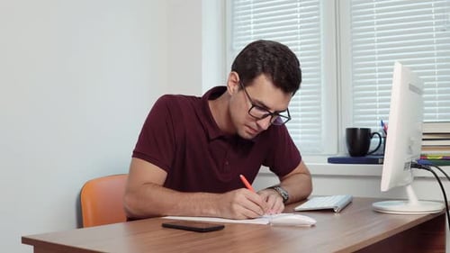 Young Office Worker in Glasses Making Notes on the Piece of Paper Then Making a Mistake Crumple It