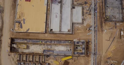 Aerial footage of a large scale construction site with trucks and tractors