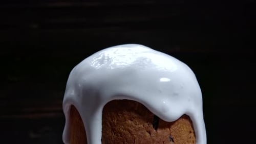 Rotierende Oster-Kuchendekoration mit weißer Glasur und bunter Zuckerstreusel Traditionelle Bäckerei