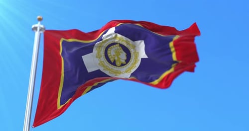 Waving Flag with Emblem Against Blue Sky