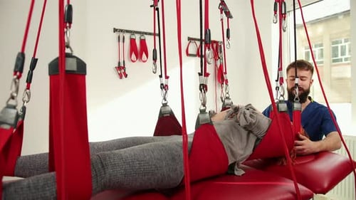 Woman Undergoing Physiotherapy With Suspension System