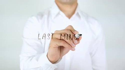 Man Writes Last Minute on Clear Surface