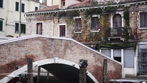 Stylish Man Takes Photo Standing on Ancient Bridge in City