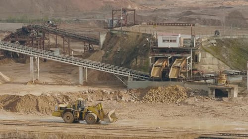 LKW-Maschine arbeitet am bewölkten Sommertag im Sandballaststeinbruch