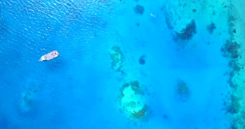 Tropical overhead tourism shot of a white sandy paradise beach and blue water background in high res