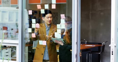 Business executives discussing over sticky notes