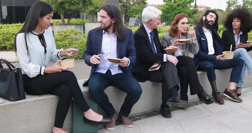 Multiethnic business people doing lunch break outdoor from office building