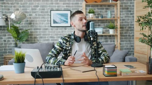 Handsome Young Man Blogger Recording Audio Talking in Microphone in Studio