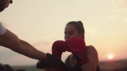 Confident Athlete in Boxing Gloves Trains on Field