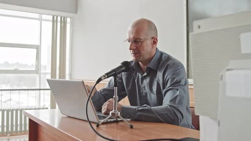 Male Professor Speaking in Microphone during Lecture