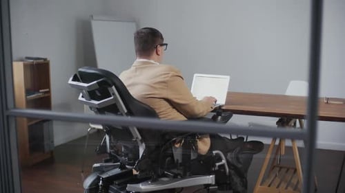 Man in Wheelchair Working in Office