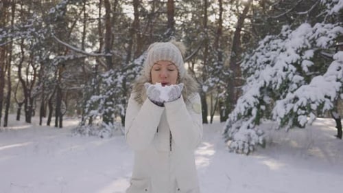 Woman Blowing Snow in Winter Wonderland