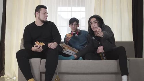Portrait of Three Caucasian Best Friends Watching Football Match, Eating Pizza and Drinking Beer