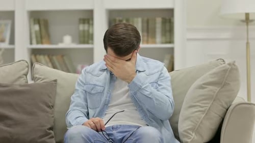 Stressed Young Man with Headache at Home