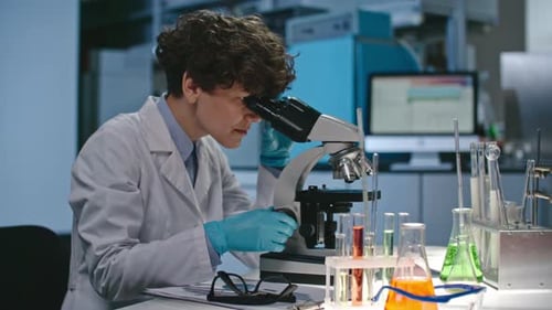 Woman Scientist Using Microscope in Bright Laboratory