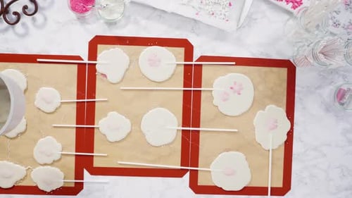 Flat lay. Pouring caramelized sugar on silicone mats to make homemade lollipops.