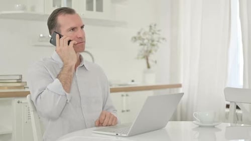 Man Smiling While Talking on Smartphone