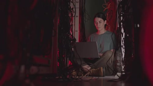 Caucasian IT Specialist on Floor of Data Center