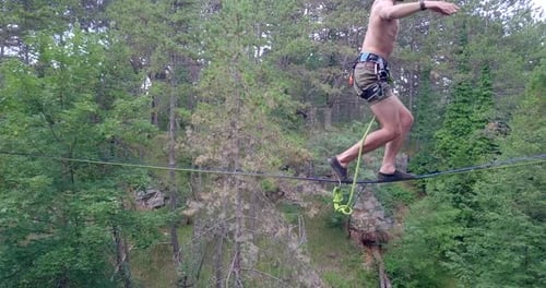 Person Walks Tightrope in Forest