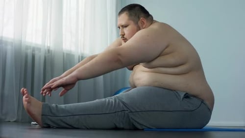 Man Stretching Indoors on Yoga Mat