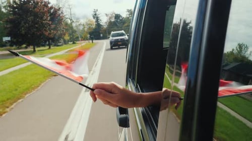 A Hand Holds a Canadian Flag