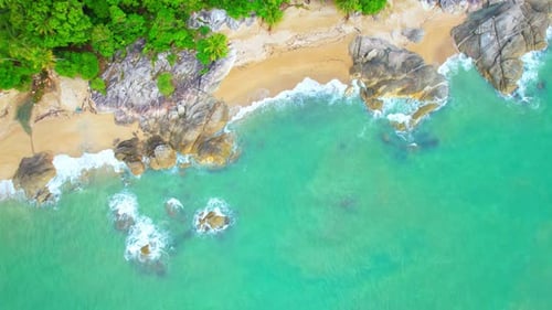 Aerial Top views over beaches, ocean waves crashing on rocks and sand