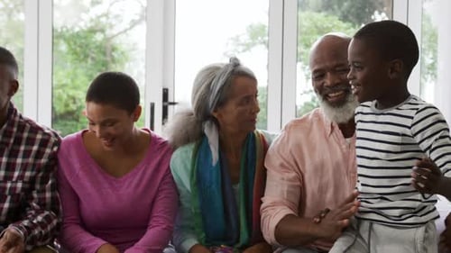 Generations Gather Together on Sofa Laughing