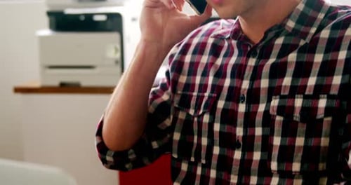 Young Adult Talking on Phone in Office