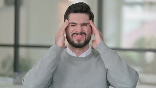 Man Experiencing Headache and Discomfort Indoors
