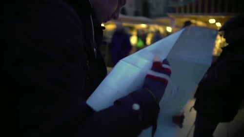 Man Studies Map in Crowded European Town Square