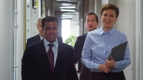 Business Team Walking Through Modern Office Hallway