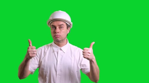 Young Male Engineer in White Hardhat and Shirt Standing Smiling and Doing Thumbs Up on Green Screen