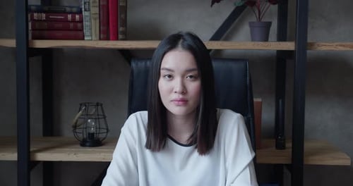 Serious Young Woman Stares in Office Setting