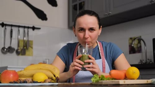 Smiling Housewife Enjoying Green Detox Smoothie