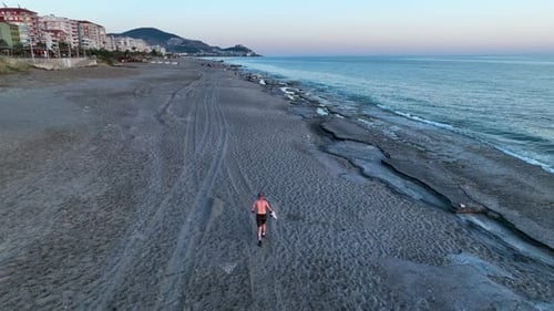 A man runs on the beach aerial view 4 K Turkey Alanya