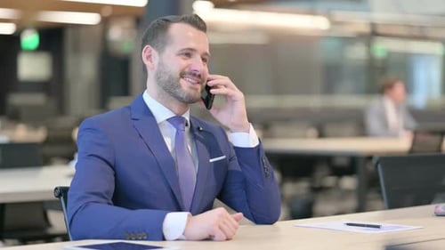 Man in Suit Talks on Phone at Office