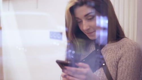 Young Woman Using Smartphone Indoors near Window
